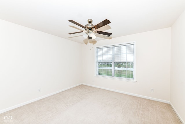 spare room featuring ceiling fan and light colored carpet