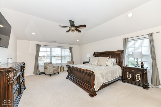 carpeted bedroom featuring ceiling fan, vaulted ceiling, and multiple windows