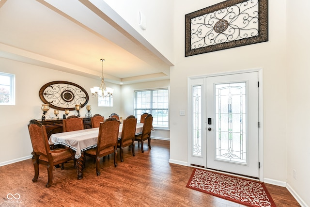 entrance foyer with an inviting chandelier and dark hardwood / wood-style flooring