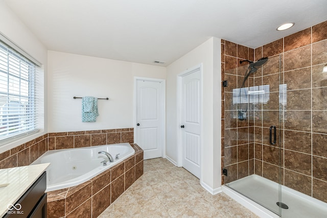 bathroom with plus walk in shower, tile patterned flooring, and vanity