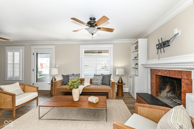 living room featuring ceiling fan, crown molding, and a healthy amount of sunlight