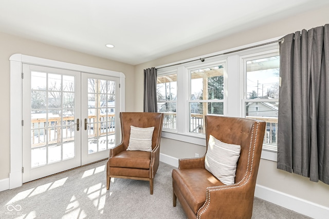 sitting room featuring light carpet and french doors