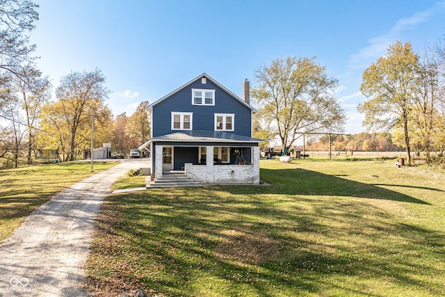 rear view of house with covered porch and a lawn