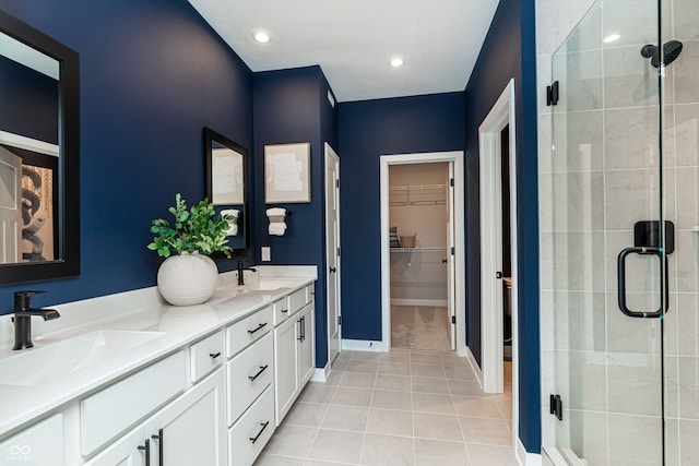 bathroom with a shower with door, vanity, and tile patterned floors