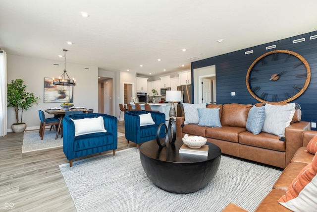 living room with a chandelier and light hardwood / wood-style flooring