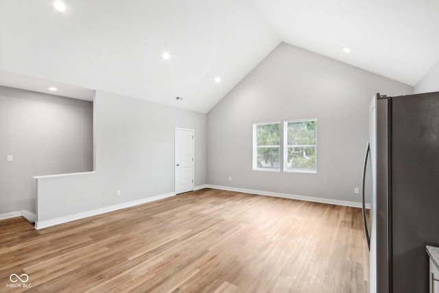 unfurnished living room featuring high vaulted ceiling and light hardwood / wood-style flooring