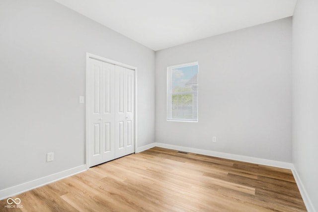 unfurnished bedroom featuring hardwood / wood-style flooring and a closet