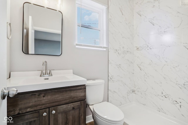 bathroom with a shower, vanity, and toilet