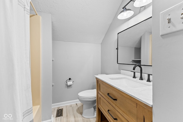 bathroom with walk in shower, hardwood / wood-style floors, vaulted ceiling, toilet, and vanity