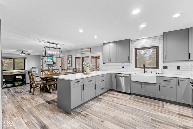 kitchen with kitchen peninsula, stainless steel dishwasher, ceiling fan, sink, and gray cabinets