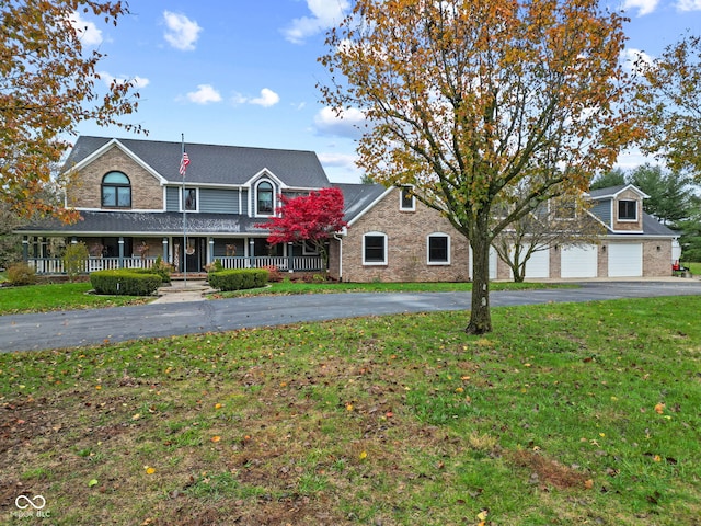 view of front of property with a front lawn, a porch, and a garage