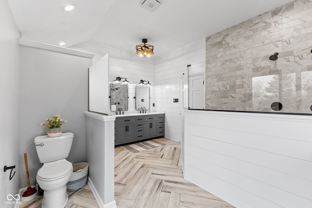 bathroom featuring vanity, toilet, and a tile shower