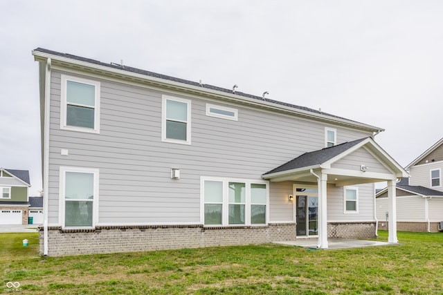 back of property with a patio area, a yard, and a garage