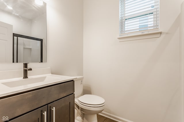 bathroom with hardwood / wood-style floors, vanity, and toilet