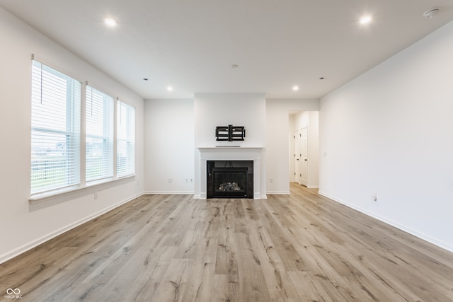 unfurnished living room featuring light hardwood / wood-style flooring and plenty of natural light