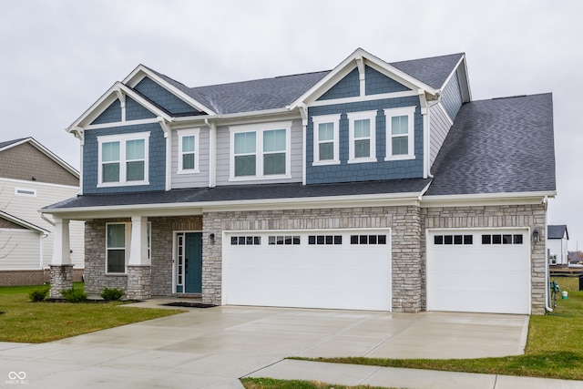 craftsman inspired home featuring a garage and a front yard