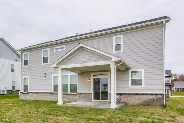 rear view of house featuring a lawn and cooling unit