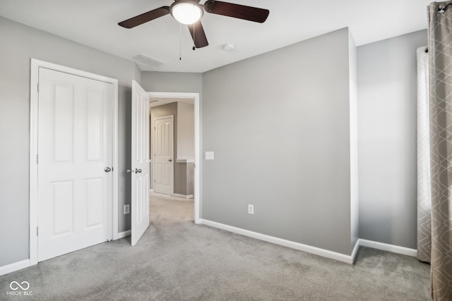 unfurnished bedroom with ceiling fan and light colored carpet