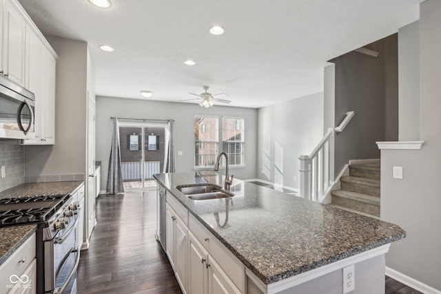 kitchen featuring stainless steel appliances, sink, a center island with sink, and white cabinets