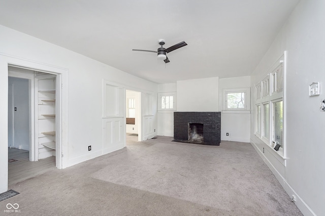 unfurnished living room with light carpet, ceiling fan, and a brick fireplace