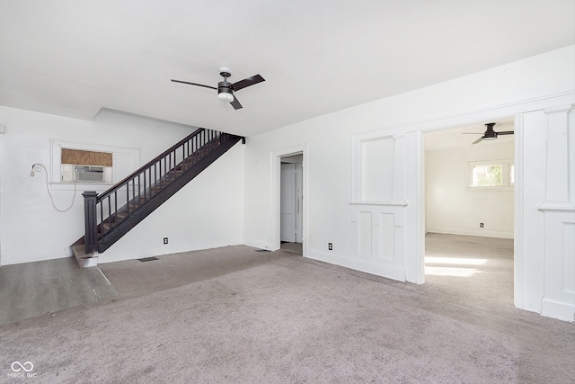 unfurnished living room with cooling unit, light colored carpet, and ceiling fan