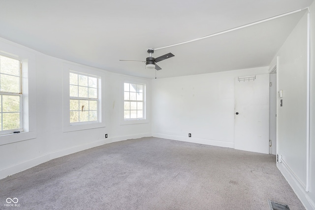 spare room with light carpet, a healthy amount of sunlight, and ceiling fan