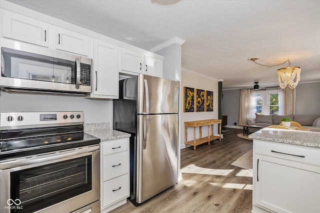 kitchen featuring light wood-type flooring, white cabinetry, ornamental molding, and appliances with stainless steel finishes