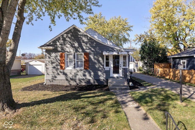 view of front of house with a garage, an outbuilding, and a front lawn