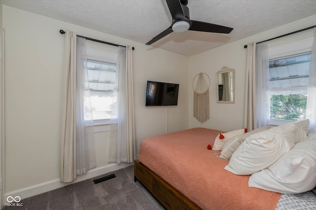 carpeted bedroom with ceiling fan and a textured ceiling