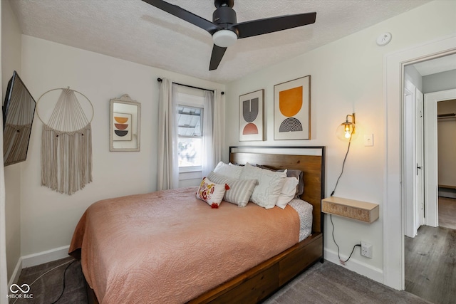 bedroom featuring a textured ceiling, dark hardwood / wood-style flooring, and ceiling fan