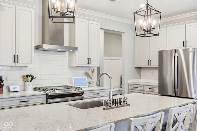 kitchen featuring pendant lighting, a breakfast bar, wall chimney exhaust hood, white cabinetry, and stainless steel appliances