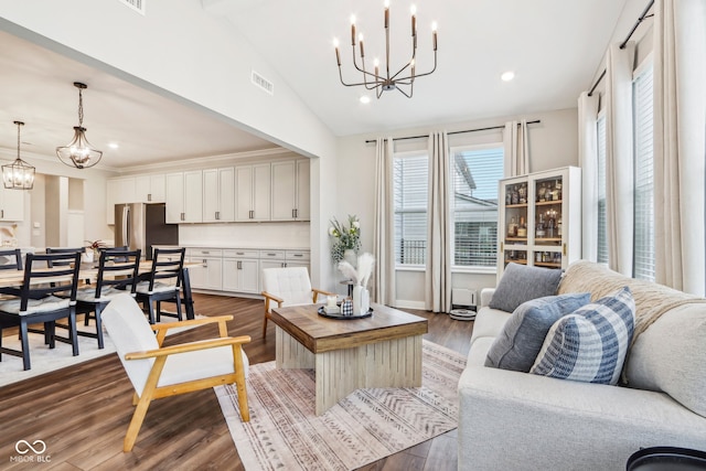 living room featuring a chandelier, dark wood-type flooring, and lofted ceiling