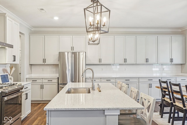 kitchen with sink, hanging light fixtures, a kitchen breakfast bar, a kitchen island with sink, and appliances with stainless steel finishes