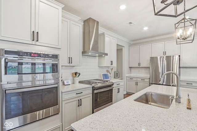 kitchen featuring wall chimney range hood, sink, light stone countertops, ornamental molding, and stainless steel appliances