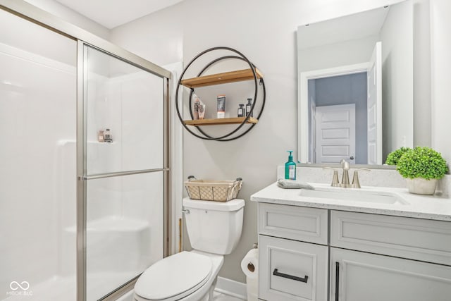 bathroom featuring toilet, an enclosed shower, and vanity