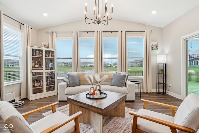 living room featuring dark hardwood / wood-style flooring, vaulted ceiling, and an inviting chandelier