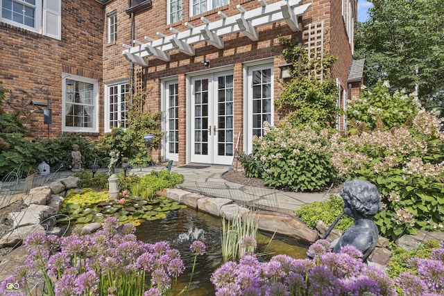 doorway to property with a small pond and french doors