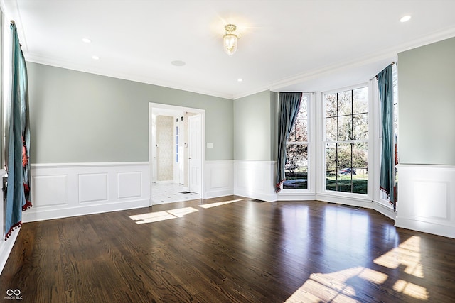 empty room with dark hardwood / wood-style floors and crown molding