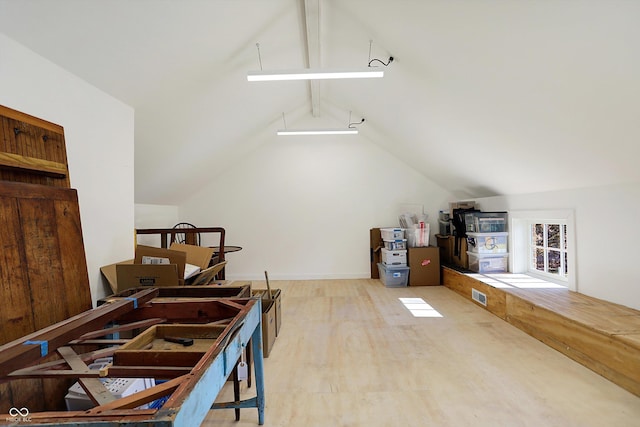 additional living space featuring vaulted ceiling with beams and light hardwood / wood-style flooring