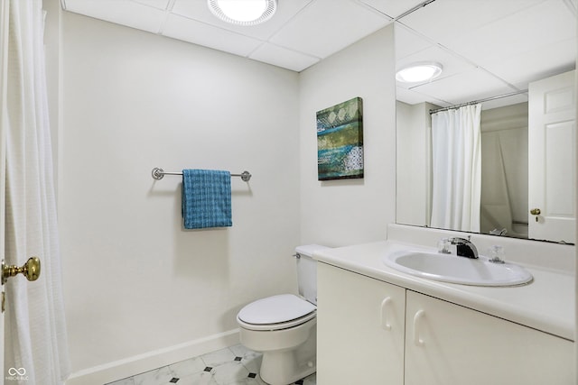 bathroom with a paneled ceiling, vanity, and toilet