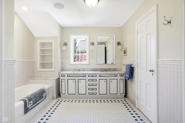 bathroom featuring tile patterned flooring, vanity, tile walls, and a tub