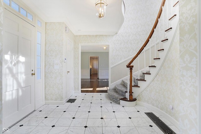 2505 Riverside Dr, Columbus, IN 47201 - foyer entrance featuring wallpapered walls, stairway, crown molding, and baseboards
