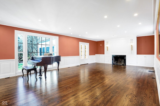 living room featuring dark hardwood / wood-style floors, a healthy amount of sunlight, and crown molding