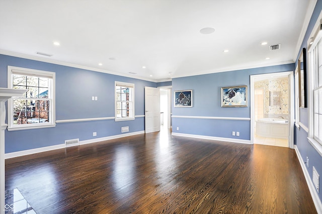 spare room with crown molding, plenty of natural light, and wood-type flooring