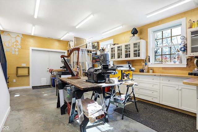 2505 Riverside Dr, Columbus, IN 47201 - kitchen featuring concrete floors, glass insert cabinets, white cabinets, and baseboards