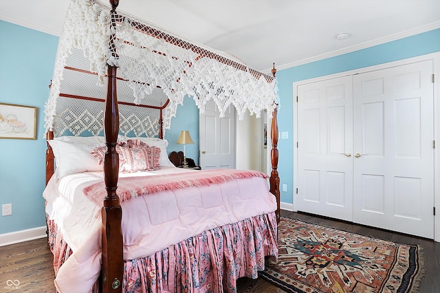 bedroom with a closet, dark hardwood / wood-style floors, and ornamental molding