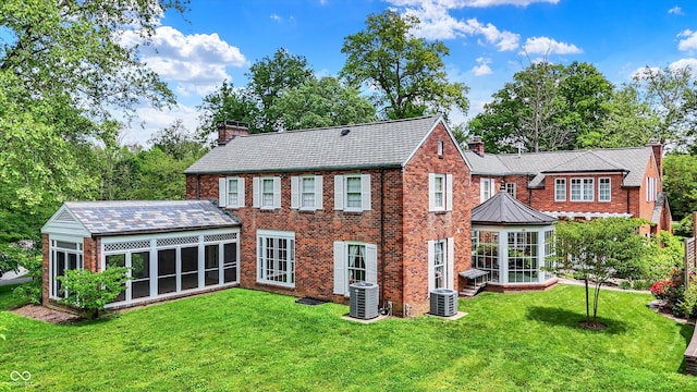 2505 Riverside Dr, Columbus, IN 47201 - back of house featuring a chimney, a sunroom, brick siding, and a lawn