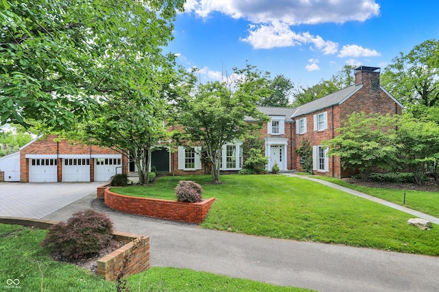2505 Riverside Dr, Columbus, IN 47201 - view of front of house with brick siding, a front lawn, a chimney, and driveway