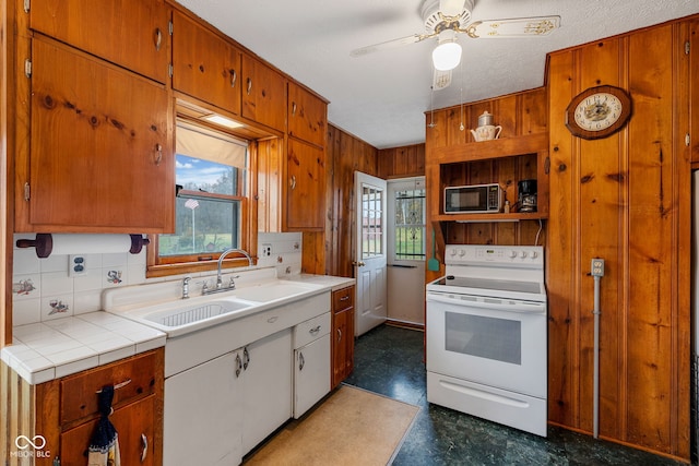 kitchen with white electric range, backsplash, sink, a textured ceiling, and ceiling fan