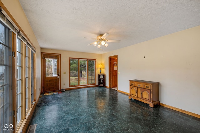 empty room featuring a textured ceiling and ceiling fan